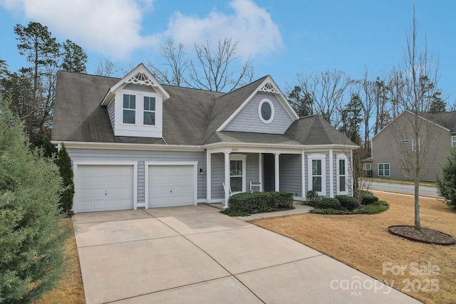 view of front of property with a garage, a front yard, covered porch, and driveway