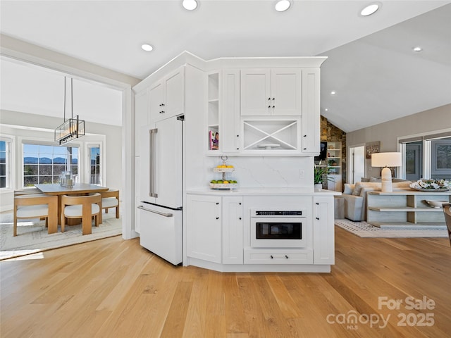 kitchen with light wood-type flooring, white appliances, white cabinets, and vaulted ceiling