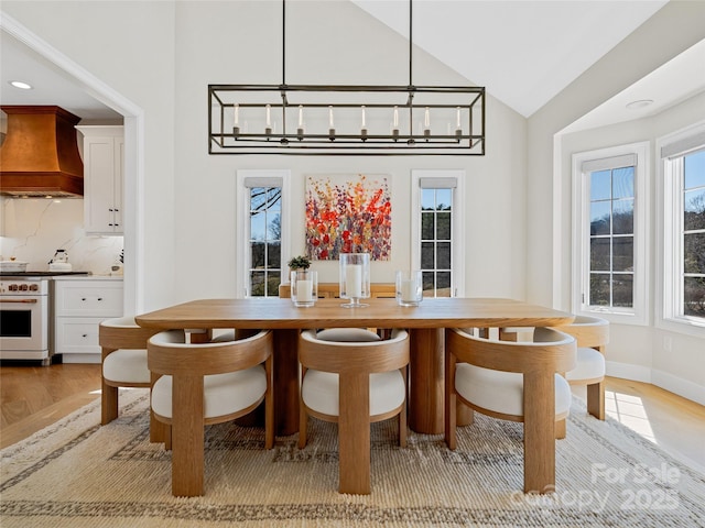 dining area featuring recessed lighting, light wood-type flooring, baseboards, and vaulted ceiling