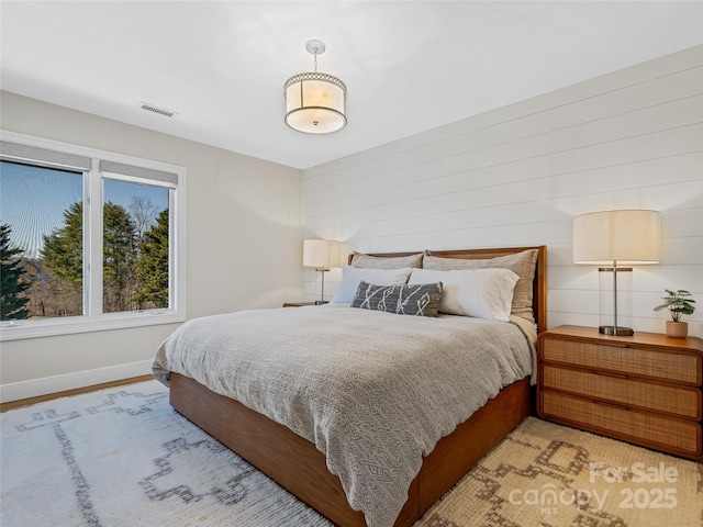 bedroom featuring visible vents, light wood-style flooring, and baseboards