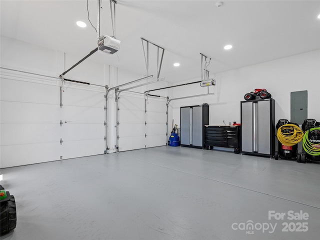 garage featuring electric panel, recessed lighting, and a garage door opener