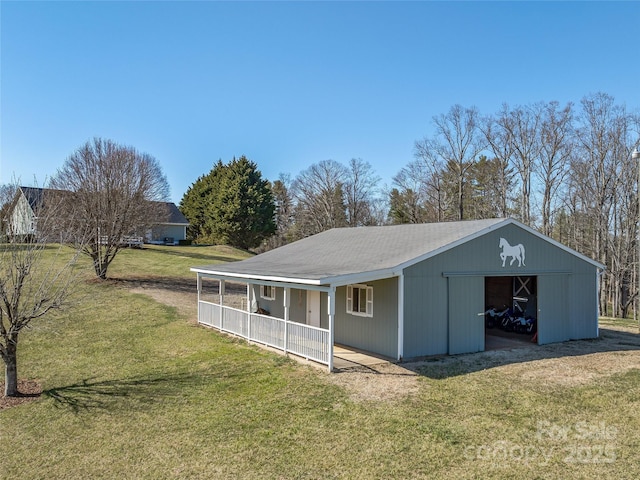 exterior space featuring an outbuilding, a detached garage, and a front yard