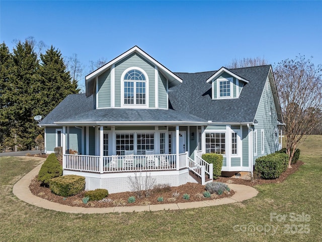 view of front facade featuring roof with shingles, covered porch, and a front yard