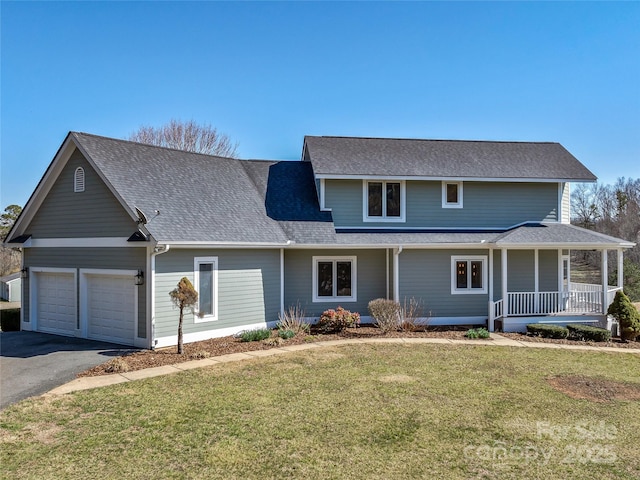 traditional home featuring a front lawn, aphalt driveway, a porch, an attached garage, and a shingled roof