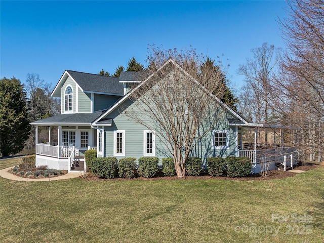 view of front facade featuring a front lawn, covered porch, and a shingled roof