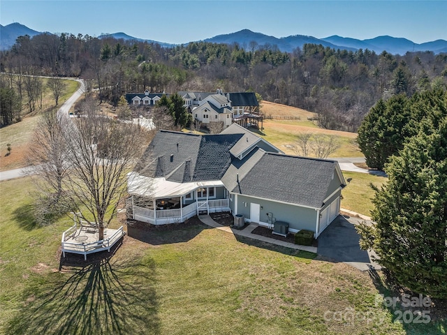 drone / aerial view featuring a mountain view and a wooded view