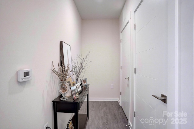 hall featuring dark wood-type flooring and baseboards