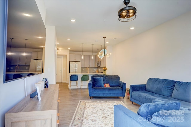 living area featuring light wood finished floors and recessed lighting