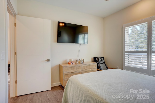 bedroom with baseboards and light wood-style floors