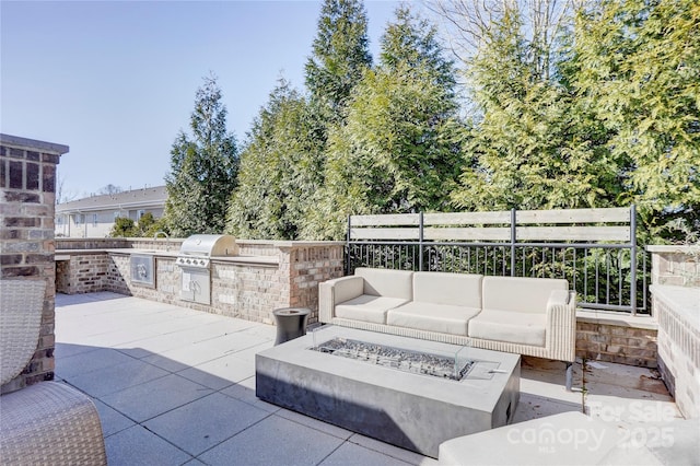 view of patio with an outdoor living space with a fire pit, an outdoor kitchen, a grill, a sink, and fence