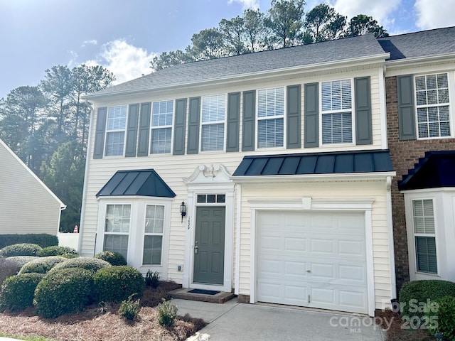 view of front of house with a standing seam roof, driveway, and metal roof