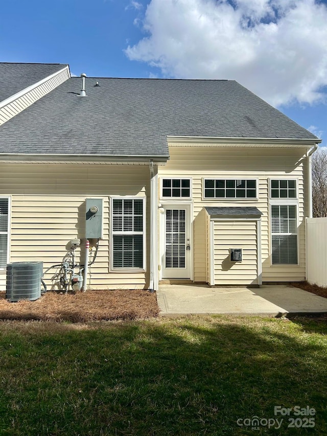 back of house with a yard, a shingled roof, cooling unit, and a patio