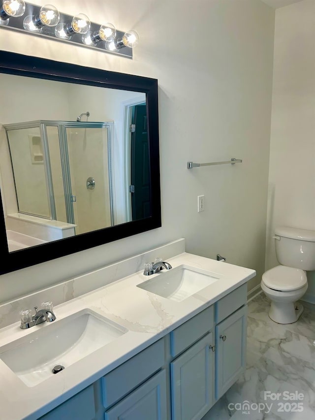 bathroom featuring marble finish floor, a sink, toilet, and a shower stall