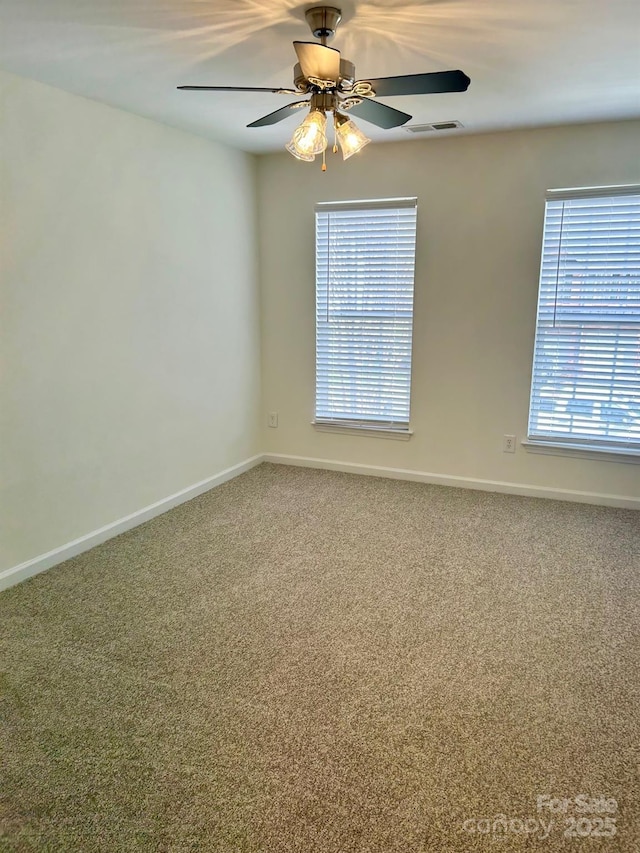 unfurnished room with a wealth of natural light, carpet flooring, and visible vents