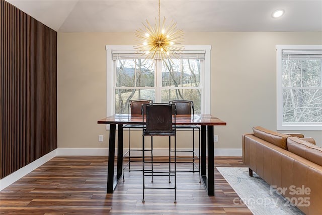 dining space featuring plenty of natural light, an inviting chandelier, and dark wood-style flooring