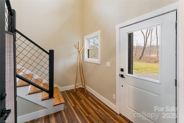 interior space featuring baseboards, wood finished floors, and stairs