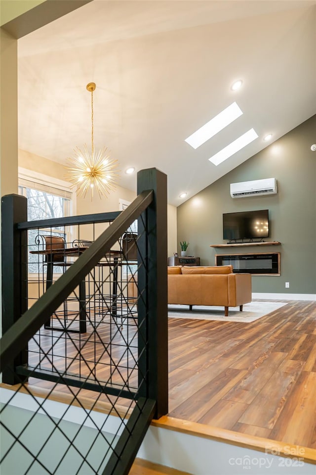 interior space featuring a chandelier, a wall mounted air conditioner, recessed lighting, vaulted ceiling with skylight, and wood finished floors