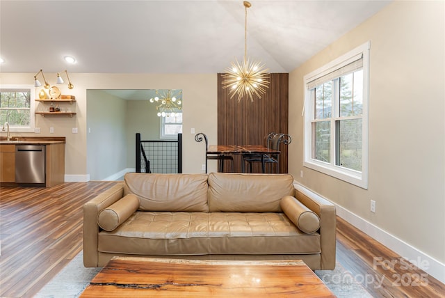 living room with a chandelier, a healthy amount of sunlight, and wood finished floors