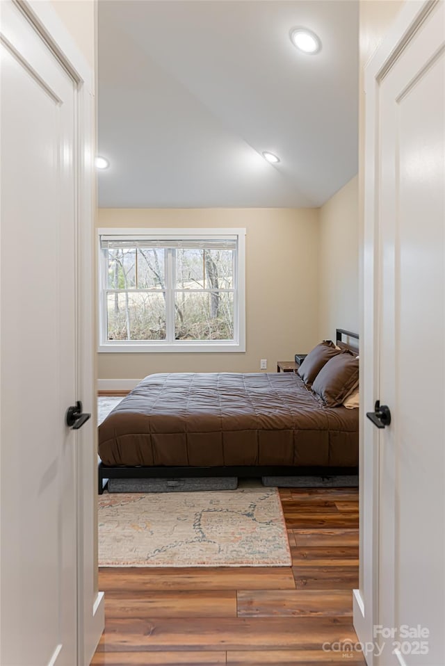 bedroom featuring recessed lighting, lofted ceiling, and wood finished floors