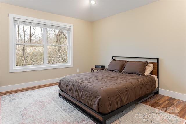 bedroom featuring baseboards and wood finished floors