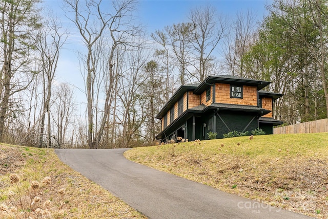 view of home's exterior featuring fence and a lawn