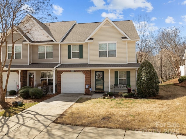 multi unit property with brick siding, covered porch, concrete driveway, and a front lawn