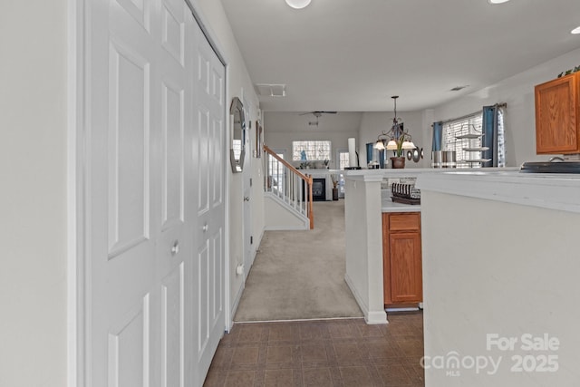 kitchen with light countertops, visible vents, a wealth of natural light, and brown cabinets