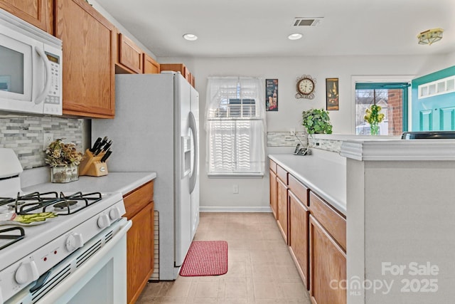 kitchen with white appliances, visible vents, recessed lighting, decorative backsplash, and light countertops