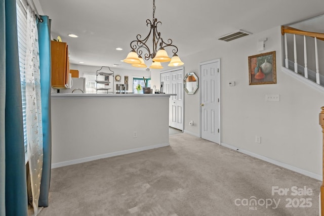 kitchen featuring visible vents, decorative light fixtures, light colored carpet, recessed lighting, and brown cabinetry