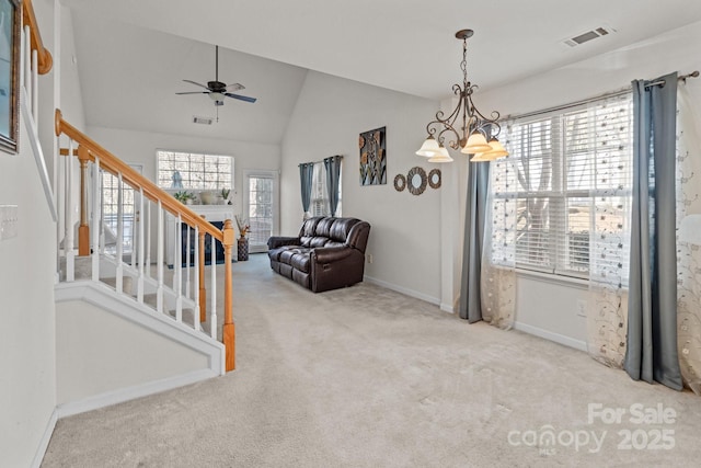 interior space with visible vents, stairs, lofted ceiling, carpet flooring, and ceiling fan with notable chandelier