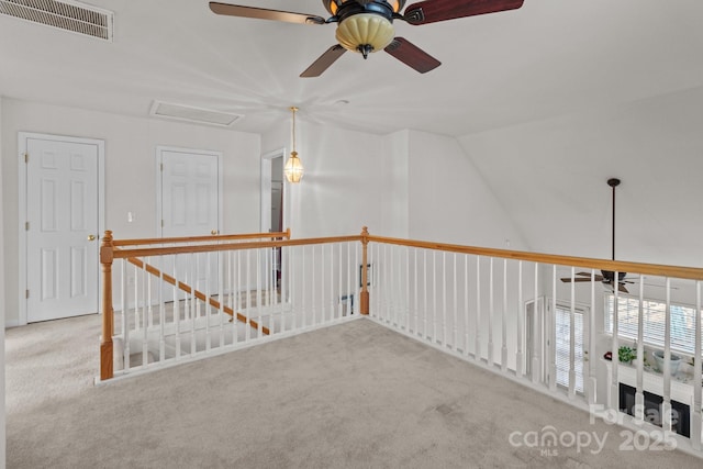 hallway featuring vaulted ceiling, visible vents, and carpet floors