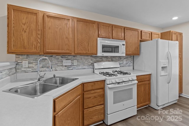 2592 Brackley Pl NW, Concord, NC 28027 - kitchen with white appliances, a sink, light countertops, wood finished floors, and recessed lighting