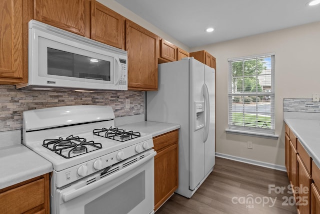 2592 Brackley Pl NW, Concord, NC 28027 - kitchen featuring white appliances, brown cabinets, light countertops, tasteful backsplash, and recessed lighting
