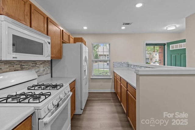 2592 Brackley Pl NW, Concord, NC 28027 - kitchen with white appliances, dark wood-style flooring, plenty of natural light, brown cabinets, and recessed lighting