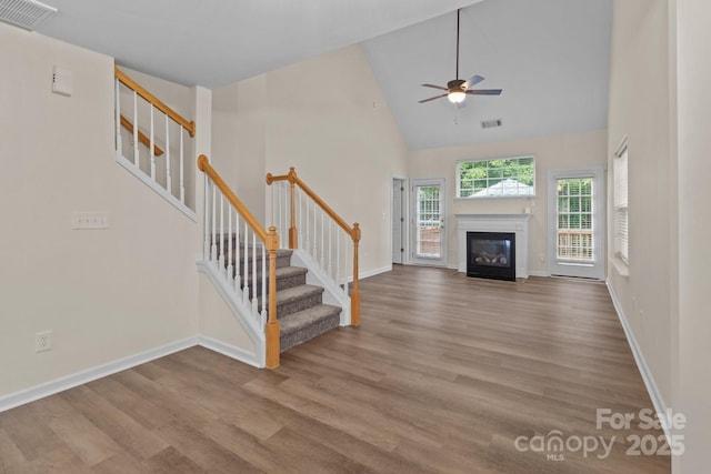 2592 Brackley Pl NW, Concord, NC 28027 - unfurnished living room featuring stairway, wood finished floors, a ceiling fan, and high vaulted ceiling