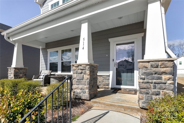 entrance to property featuring stone siding and a porch