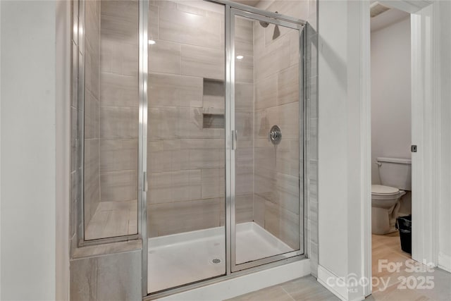 full bathroom featuring a stall shower and toilet