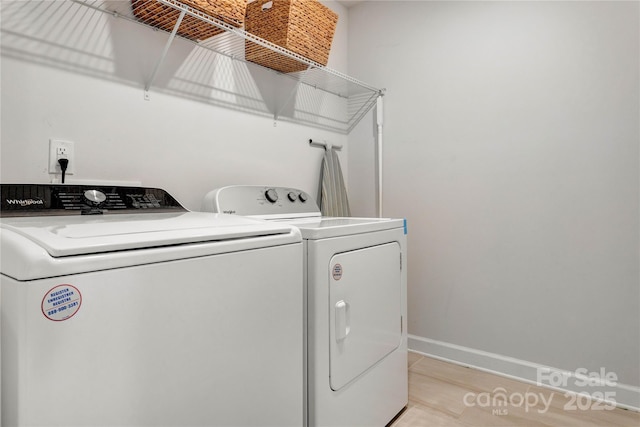 clothes washing area with laundry area, baseboards, and washer and dryer