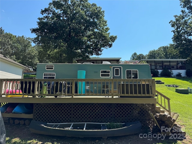 rear view of property featuring a lawn and a wooden deck