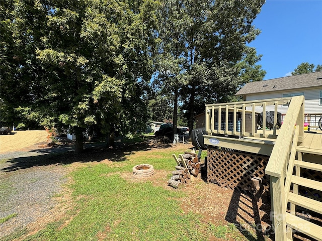 view of yard with a deck and an outdoor fire pit