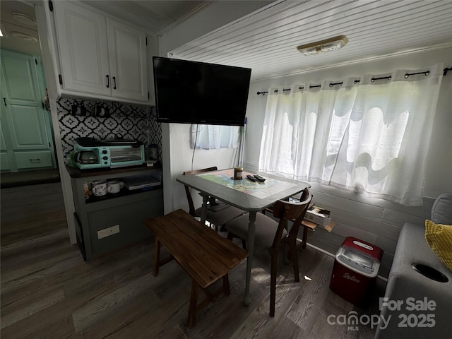 dining area with dark wood-style flooring and a toaster