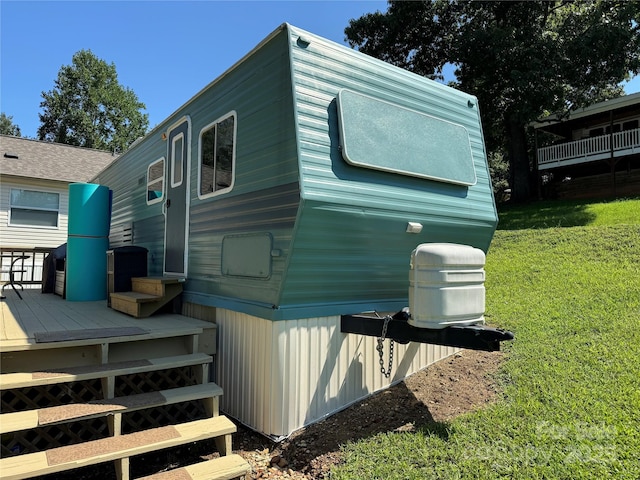 view of side of property with a yard and a wooden deck