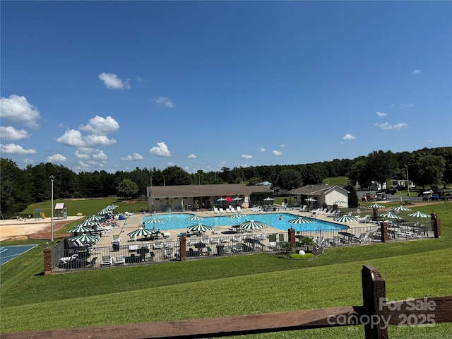 pool with fence, a lawn, and a patio