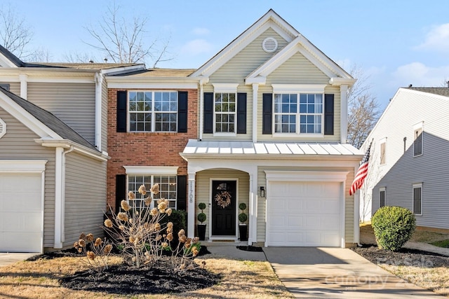 traditional-style house with driveway, a standing seam roof, a garage, and brick siding