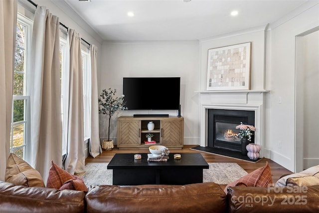 living room featuring a fireplace with flush hearth, wood finished floors, and recessed lighting