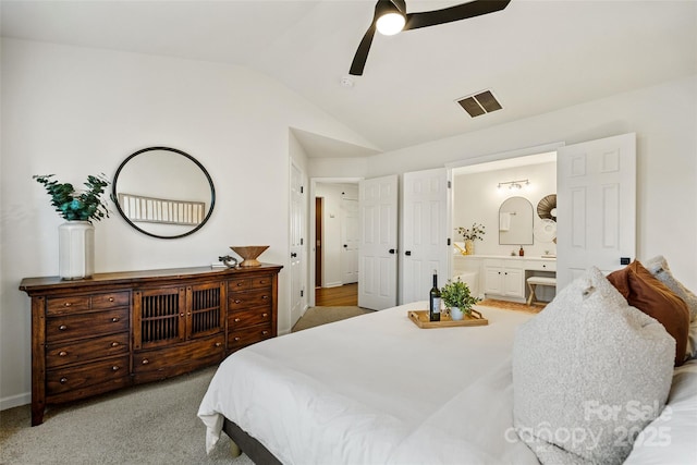 bedroom featuring light carpet, visible vents, connected bathroom, ceiling fan, and vaulted ceiling