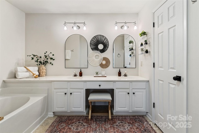 full bathroom featuring double vanity, a tub to relax in, and a sink