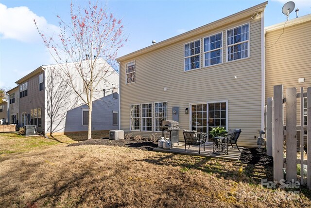 rear view of property with a patio, a yard, and cooling unit