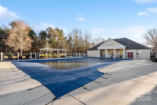 pool with a pergola, fence, and a patio