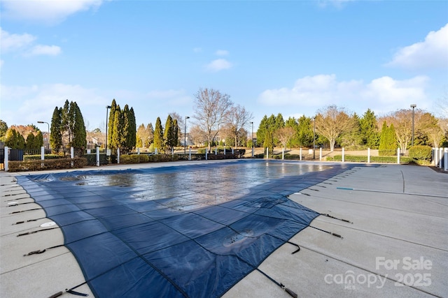 community pool with fence and a patio